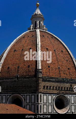 Zwei der acht „Segel“ oder Pendentive der Kuppel der Kathedrale von Florenz in der Toskana, Italien, gekrönt von einem weißen Marmorturm mit Aussichtsplattform am Fuß des Turms. Die achteckige Kuppel ist mit Terrakottafliesen bedeckt, die von acht Rippen aus weißem Marmor gekennzeichnet sind. Stockfoto