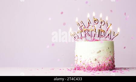 Geburtstagskuchen mit rosa und goldenen Geburtstagskerzen, die alles Gute zum Geburtstag auf rosa Hintergrund schreiben Stockfoto