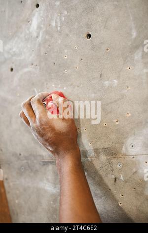 Zugeschnittene Ansicht der Hand eines sportlichen afroamerikaners auf Felsbrocken an der Felswände zum Klettern, Sport Stockfoto