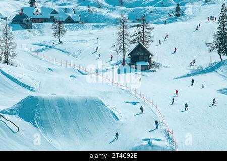 Große Gruppe von Skifahrern, die einen sonnigen Wintertag auf der Skipiste genießen, unerkennbare Menschen, die in Slowenien Ski fahren Stockfoto