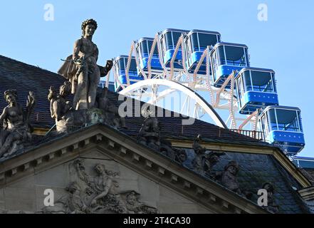 Stuttgart, Deutschland. 30. Oktober 2023. Auf dem Dach des Neuen Schlosses vor einem temporären Riesenrad am Schlossplatz erscheint eine historische Apollonstatue. Quelle: Bernd Weißbrod/dpa/Alamy Live News Stockfoto