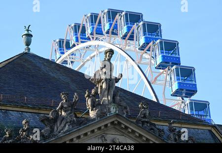 Stuttgart, Deutschland. 30. Oktober 2023. Auf dem Dach des Neuen Schlosses vor einem temporären Riesenrad am Schlossplatz erscheint eine historische Apollonstatue. Quelle: Bernd Weißbrod/dpa/Alamy Live News Stockfoto