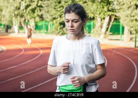 Attraktive junge Frau im Sportbekleidungsjoggen im Stadion. Stockfoto
