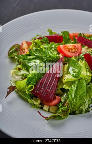 Ein Nahfoto eines Salattellers mit Salat, Tomaten, roten Rüben und Minze Stockfoto