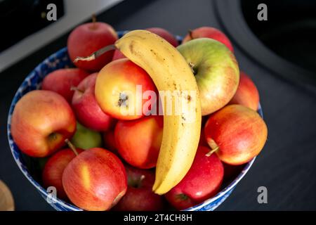 Banane und Äpfel in der Küche auf dem Küchentisch neben dem Waschbecken. Stockfoto