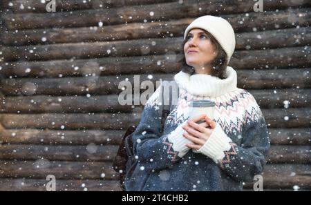 Die Frau hält eine Tasse heißes Getränk in der Hand. Stockfoto