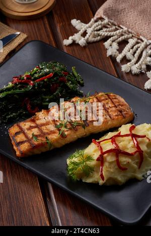 Ein Makroshooting eines Tellers Lachs mit gekochtem Gemüse auf Holzboden Stockfoto