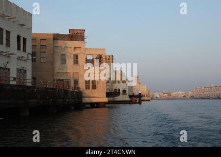 Oktober 2023, Dubai, VAE. Ein früher Morgen ab Dubai Abra mit traditionellem Gebäude und Booten. Es ist ein gewöhnlicher Mann-Reisemodus und für Touristen. Stockfoto