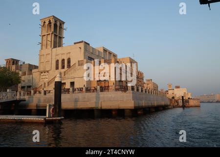 Oktober 2023, Dubai, VAE. Ein früher Morgen ab Dubai Abra mit traditionellem Gebäude und Booten. Es ist ein gewöhnlicher Mann-Reisemodus und für Touristen. Stockfoto