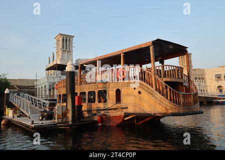 Oktober 2023, Dubai, VAE. Ein früher Morgen ab Dubai Abra mit traditionellem Gebäude und Booten. Es ist ein gewöhnlicher Mann-Reisemodus und für Touristen. Stockfoto