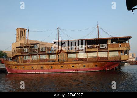 Oktober 2023, Dubai, VAE. Ein früher Morgen ab Dubai Abra mit traditionellem Gebäude und Booten. Es ist ein gewöhnlicher Mann-Reisemodus und für Touristen. Stockfoto