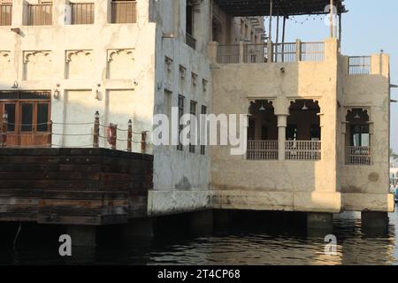 Oktober 2023, Dubai, VAE. Ein früher Morgen ab Dubai Abra mit traditionellem Gebäude und Booten. Es ist ein gewöhnlicher Mann-Reisemodus und für Touristen. Stockfoto