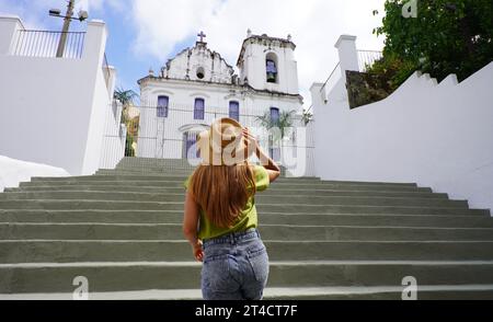 Junge Touristenfrau, die die Kirche Nossa Senhora do Rosario im historischen Zentrum von Vitoria, Espirito Santo, Brasilien besucht Stockfoto