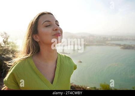 Glückliche Reisende Frau genießt entspannten Wind auf Gesicht bei Sonnenuntergang in ihrem Urlaub Stockfoto