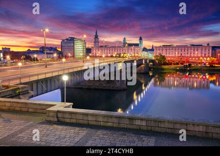 Linz, Österreich. Stadtbild des Flusses Linz, Österreich bei Sonnenaufgang im Herbst mit Reflexion der Lichter der Stadt in der Donau. Stockfoto