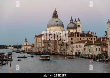 In der Abenddämmerung auf dem Canal Grande, gesäumt von Renaissancegebäuden und dem bekannten Wahrzeichen, ist die Kuppel der Basilika di Santa Maria della Salute (Kirche) Stockfoto