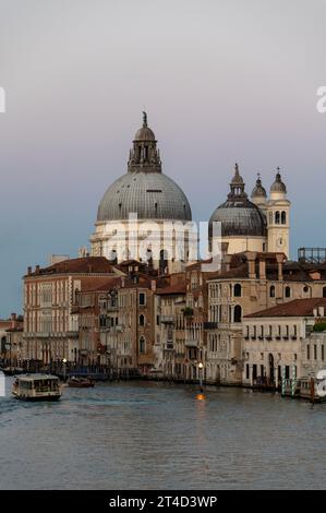 In der Abenddämmerung auf dem Canal Grande, gesäumt von Renaissancegebäuden und dem bekannten Wahrzeichen, ist die Kuppel der Basilika di Santa Maria della Salute (Kirche) Stockfoto