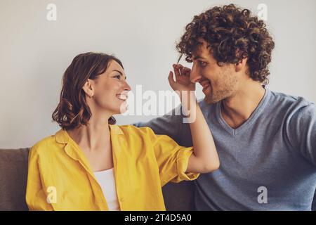 Porträt eines jungen glücklichen Paares in der Liebe. Die Frau spielt mit den lockigen Haaren des Mannes. Stockfoto