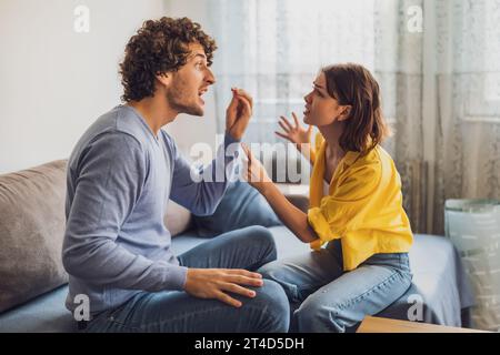 Der Mann und die Frau sitzen am Sofa und streiten. Beziehung Probleme. Stockfoto