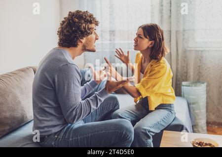 Der Mann und die Frau sitzen am Sofa und streiten. Beziehung Probleme. Stockfoto