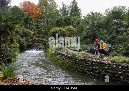 Chichester, West Sussex. 30. Oktober 2023. Die Schwestern Lara (links) und Alice Young stellten sich eine Pause zwischen starken Regenschauern in den West Dean Gardens in Chichester, West Sussex, vor. Quelle: Katie Collins/Alamy Live News Stockfoto