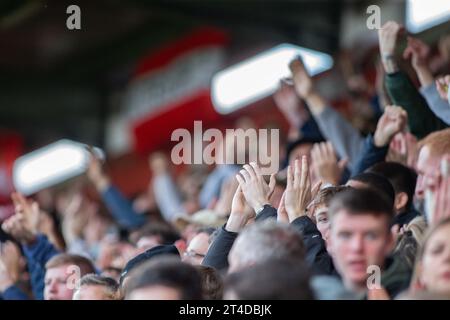 Fußballfans und -Fans klatschen und applaudieren von der Stehterrasse im Fussballstadion der unteren Liga in der EFL Stockfoto