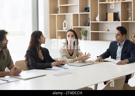 Ernsthafte, reife Geschäftsfrau, die Ideen mit Kollegen teilt Stockfoto