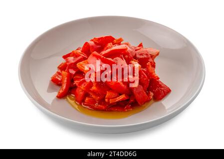 Gekochte, gehackte rote Paprika, gewürzt mit Olivenöl - Peperonata auf weißer Platte isoliert auf weiß mit Schnittpfad im Preis inbegriffen Stockfoto