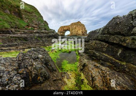 Der Pollaird Sea Arch ist ein 20 Meter hoher Meeresbogen, der von der zerklüfteten Fanad-Halbinsel in Donegal, Irland, geschnitzt wurde. Stockfoto