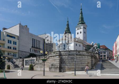 Zilina, Slowakei-26.Mai 2022: Menschen in der Fußgängerzone, Kirche der Heiligen Dreifaltigkeit auf dem Platz Andrej Hlinka am 25,2022. Mai in Zilina in der Slowakei Stockfoto