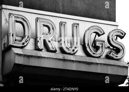 Bronx NY - 28. Oktober 2023: Schwarz-weißes Retro-Neon-Schild „Drugs“ in der Pilgrim Pharmacy Drogerie in New York City Stockfoto