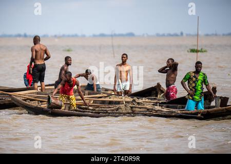 Lagos, Nigeria. 30. Oktober 2023. Männer stehen in der Lagune der Wirtschaftsmetropole Lagos. Scholz ist auf seiner dritten großen Reise nach Afrika in den fast zwei Jahren seit seiner Vereidigung. Heute besucht er Nigeria, das bevölkerungsreichste und wirtschaftlich mächtigste Land des Kontinents. Quelle: Michael Kappeler/dpa/Alamy Live News Stockfoto