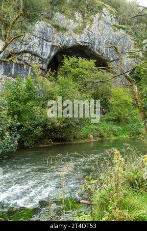 Der River Dove mit den Dove Holes Höhlen im Dovedale Valley, Peak District, Derbyshire, England Stockfoto