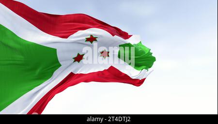 Die Nationalflagge von Burundi winkt an klaren Tagen. Weißes diagonales Kreuz, unterteilt in rote und grüne Abschnitte, drei grüne Sterne in der Mitte. 3D illustr Stockfoto