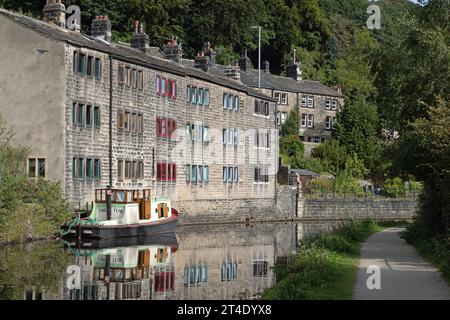 Traditionelle Reihenhütten und Boot neben dem Rochdale Canal an der Hebden Bridge West Yorkshire England Stockfoto