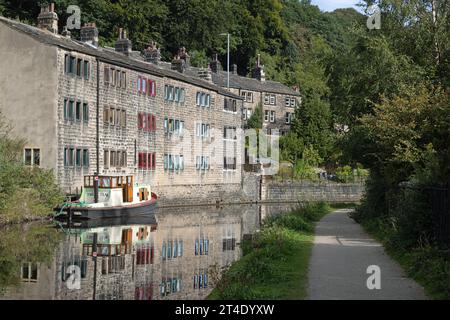 Traditionelle Reihenhütten und Boot neben dem Rochdale Canal an der Hebden Bridge West Yorkshire England Stockfoto