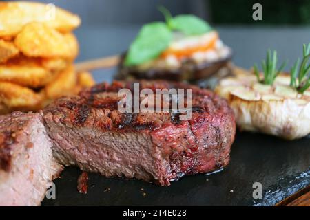 Nahaufnahme des köstlichen Pink Brown Texture of Cut Medium Well Filet Mignon Steak auf Hot Stone Plate Stockfoto