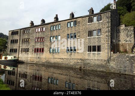 Traditionelle Reihenhütten und Boot neben dem Rochdale Canal an der Hebden Bridge West Yorkshire England Stockfoto