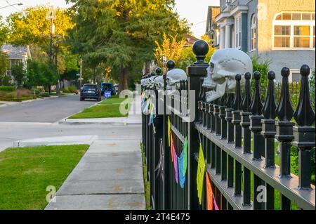 NEW ORLEANS, LA, USA - 23. OKTOBER 2023: Plastikschädel schmücken einen Metallzaun in Uptown für Halloween Stockfoto