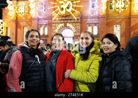 Vier Damen posieren für ein Foto, während die Lichter für das Diwali Festival of Light in Leicester eingeschaltet werden. Leicesters Feier von Diwali ist bekannt als eines der größten außerhalb Indiens. Das Festival of Light ist einer der Höhepunkte des kulturellen Kalenders der Stadt und bietet Besuchern die Möglichkeit, die unglaubliche Lichtshow, das Feuerwerk und das Essen zu genießen und sogar eine Fahrt mit dem Rad des Lichts zu Unternehmen. Stockfoto