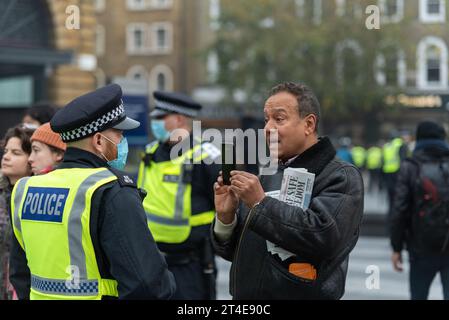 Person, die Polizist auf einem COVID 19 Coronavirus Anti-Lockdown-protestmarsch in London, Großbritannien, filmt. Videoaufzeichnung auf dem Mobiltelefon Stockfoto