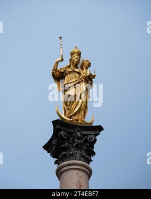 Goldene Marienstatue auf der Mariensaule am Marienplatz in München. Stockfoto