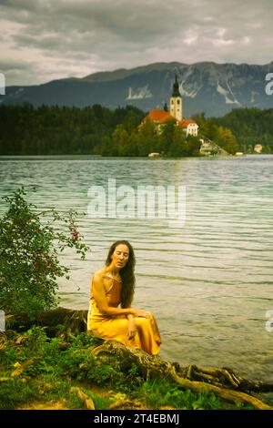 Frau in gelbem Kleid am Ufer des Bleder Sees, Slowenien III Stockfoto