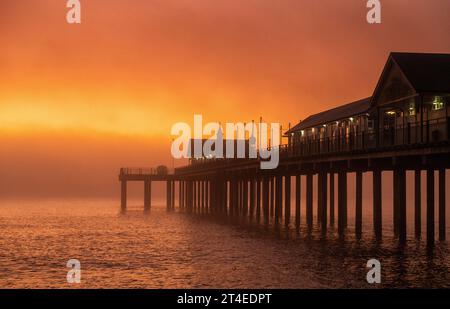 Nebliger Sonnenaufgang über dem Pier in Southwold, Suffolk England, Großbritannien Stockfoto