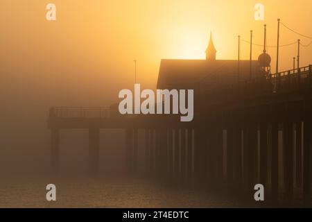 Nebliger Sonnenaufgang über dem Pier in Southwold, Suffolk England, Großbritannien Stockfoto