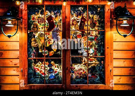 Fenster eines Baumhauses voller Weihnachtsdekorationen und Geschenke, beleuchtet mit Weihnachtslichtern bei Nacht Stockfoto