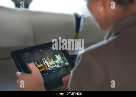 Seychellen, La Digue - 05. Oktober 2022: Frau, die zu Hause ein Tablet benutzt und auf den Bildschirm tippt Stockfoto