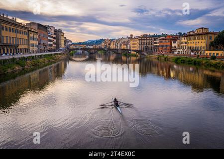 Florenz, Italien – 4. September 2023. Zwei Kajakfahrer rudern am frühen Morgen den Fluss Arno hinunter in Richtung Ponte Vecchio. Stockfoto