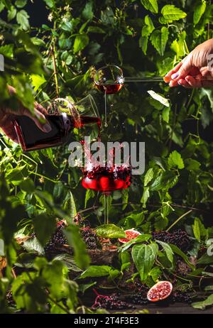 Holunderinfusion mit Ahornsirup. Frau, die Cocktails in elegantem Glas zubereitet. Erfrischendes Getränk bereit zum Trinken. Stockfoto