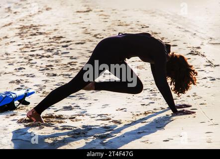 Die Silhouette der Frau (nicht erkennbare Person) wärmt sich auf, bevor sie in das Wasser an der Küste von Tel Aviv geht. Die Haare bedeckten das Gesicht, Sunny Stockfoto